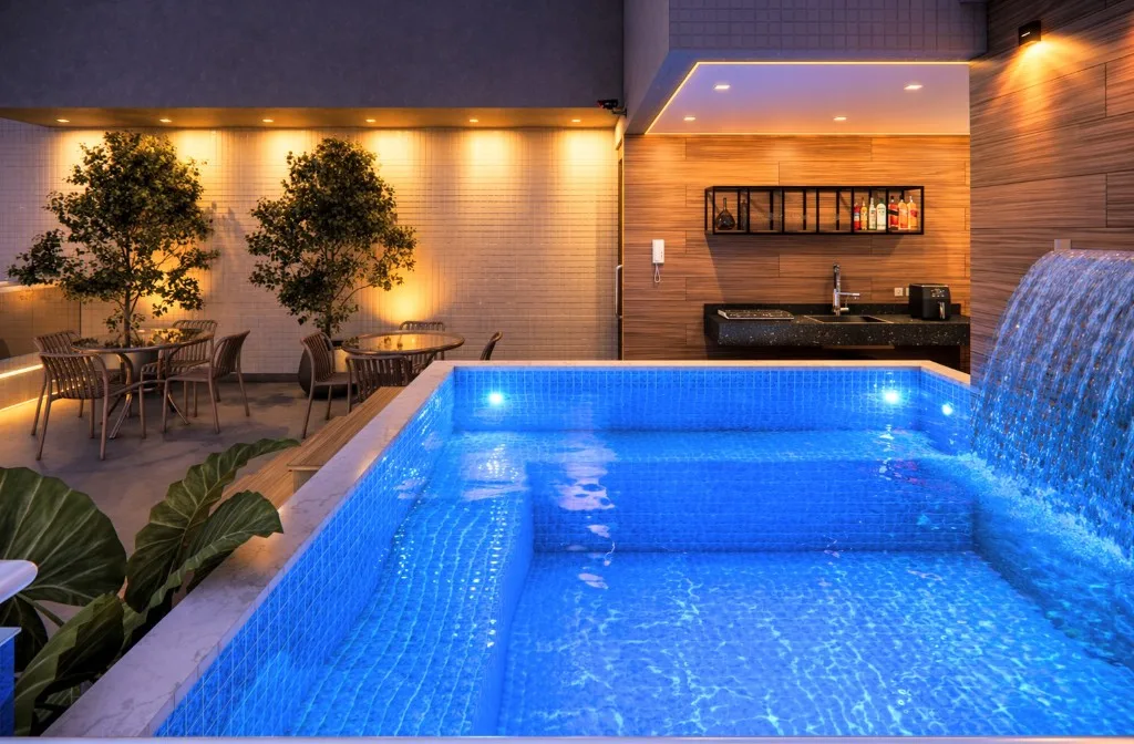 Piscina do rooftop do Wave Jacumã à noite, com cascata e iluminação azul