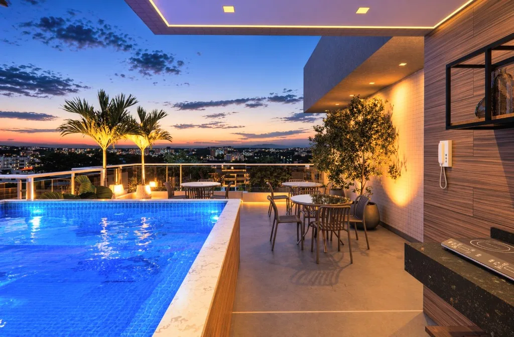 Rooftop do Wave Jacumã ao entardecer, com piscina iluminada e vista da cidade